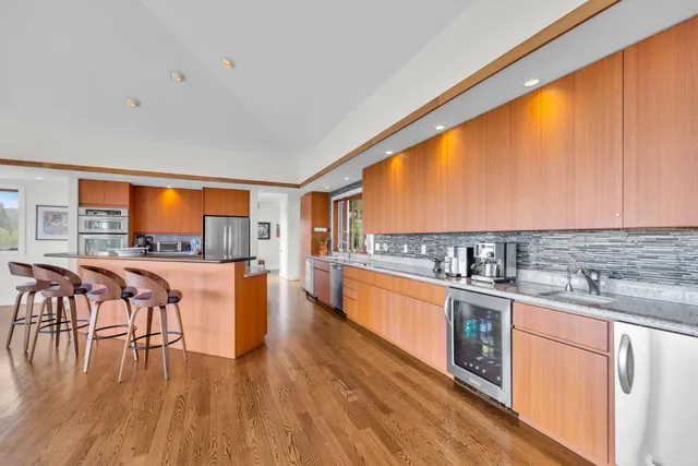 a dining table with chairs and view of kitchen