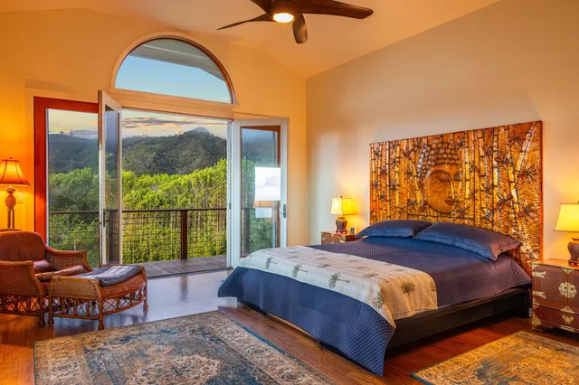 a bedroom with a bed and large windows