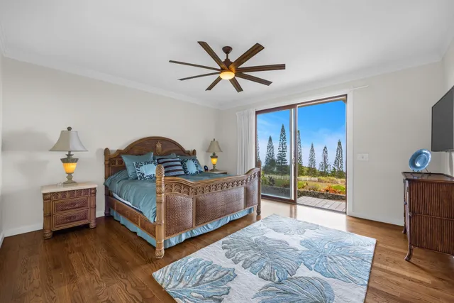 a bedroom with a bed a flat screen tv and dresser