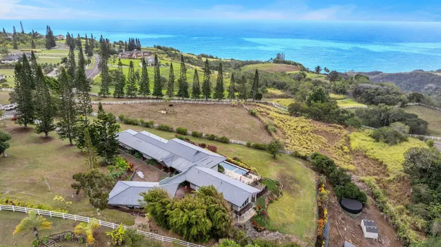 an aerial view of a city with lots of residential buildings ocean and mountain view in back