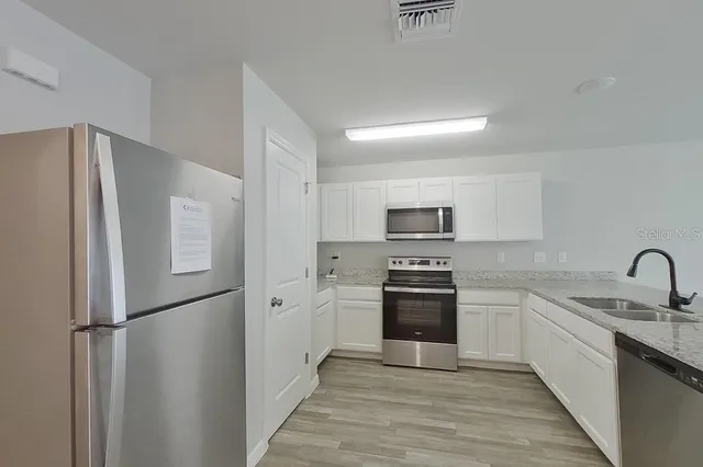 a kitchen with stainless steel appliances a refrigerator stove and sink