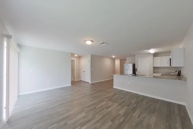a view of a kitchen with kitchen island a sink wooden floor and a counter top space