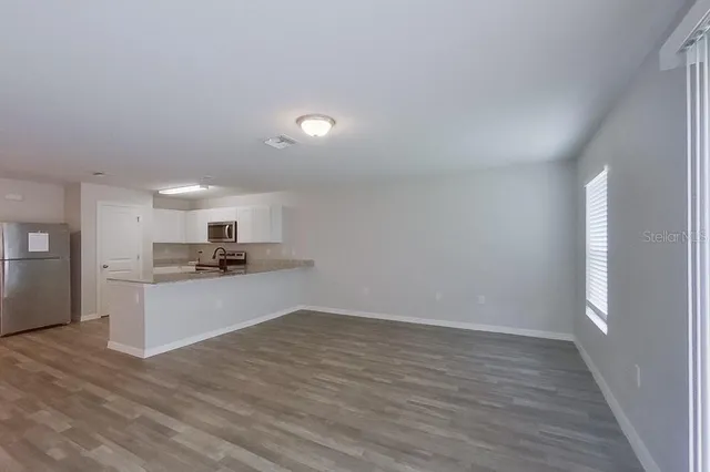 a view of kitchen with sink microwave and refrigerator