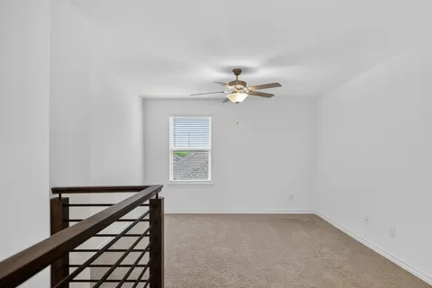 a view of an empty room with a chandelier fan