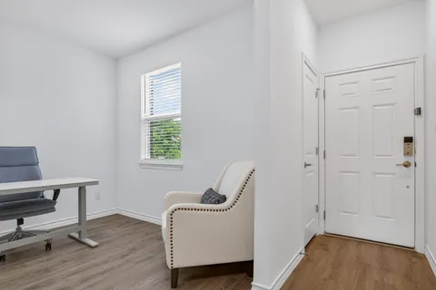 a view of a workspace with furniture and wooden floor