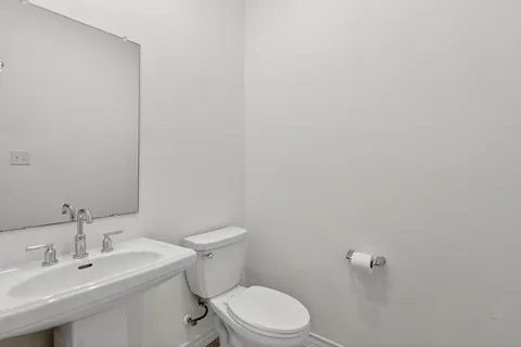 a bathroom with a sink a toilet and a mirror