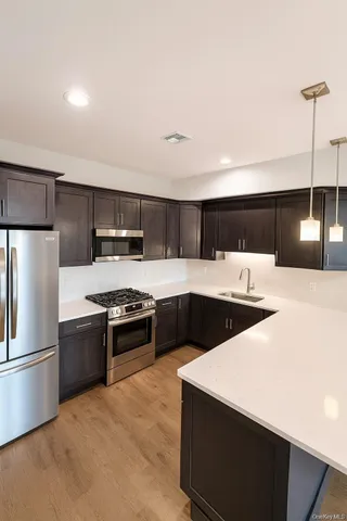 a large kitchen with a large counter top stainless steel appliances and cabinets