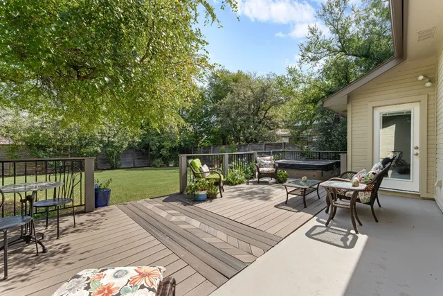 a view of a patio with a dining table and chairs with wooden floor