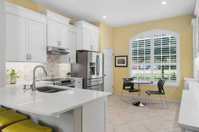 a kitchen with a table chairs and refrigerator