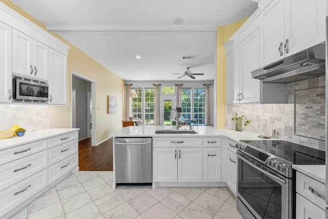 a kitchen with a stove sink and cabinets