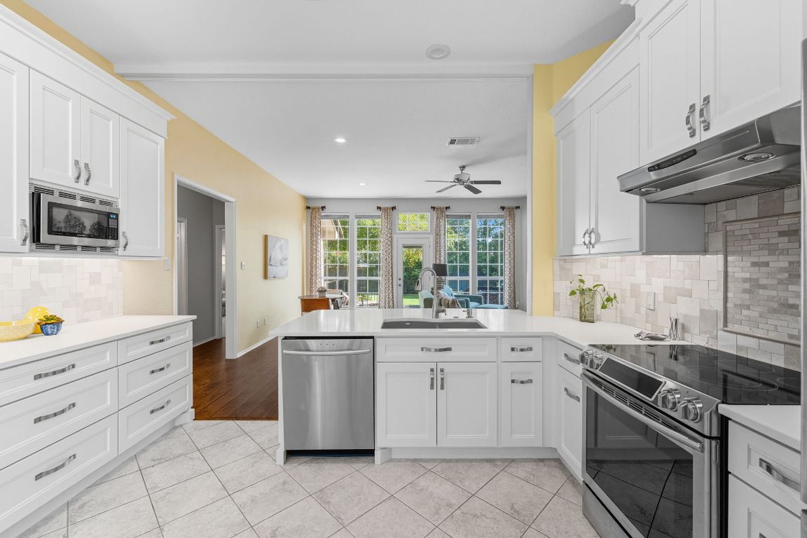 15202 Sun-Bird Lane Austin, TX 78734 - Photo 15 of 28 a kitchen with a stove sink and cabinets