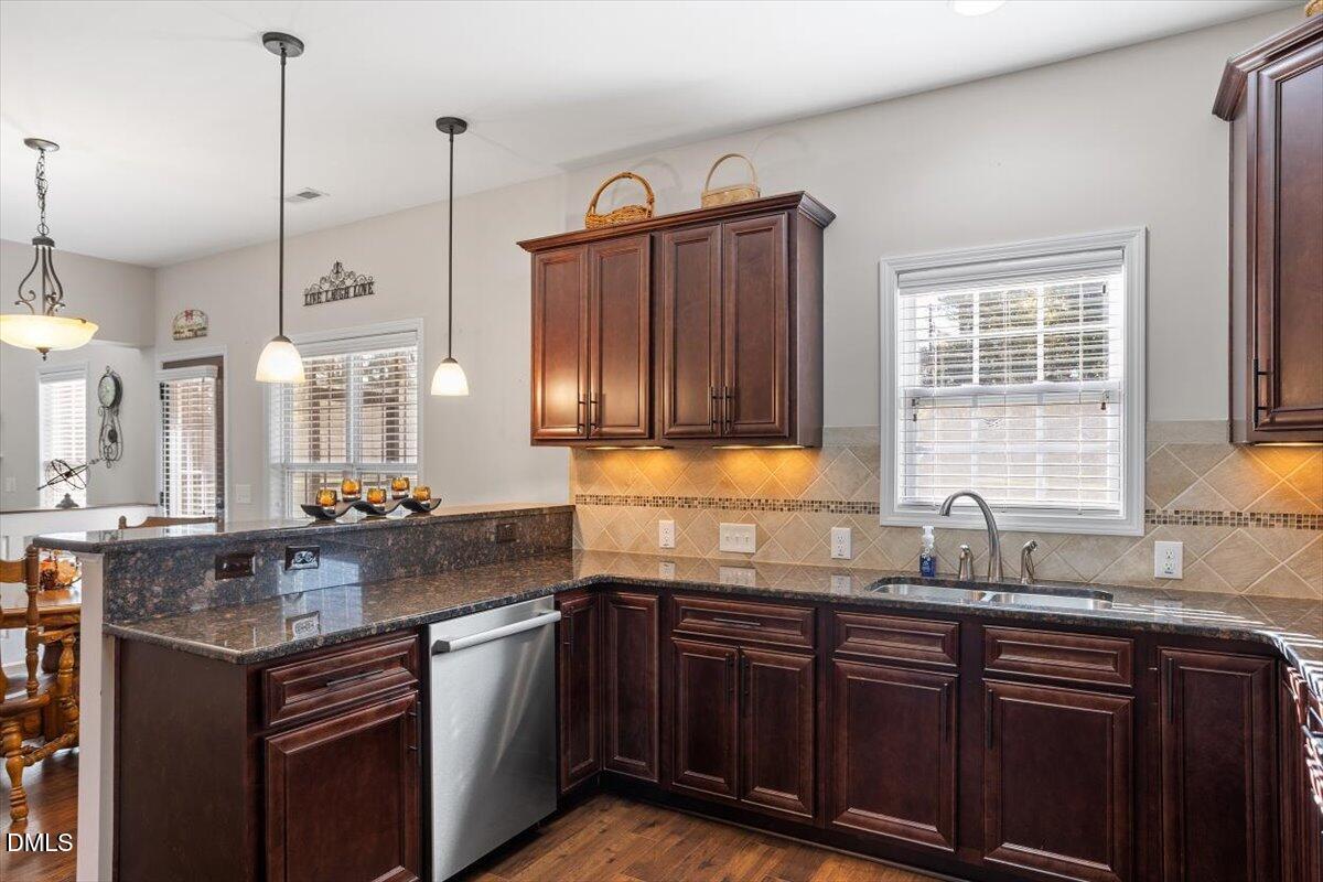 109 North Sunset Ridge Drive Willow Spring, NC 27592 - Photo 15 of 54 a kitchen with stainless steel appliances granite countertop a sink a stove and a wooden cabinets