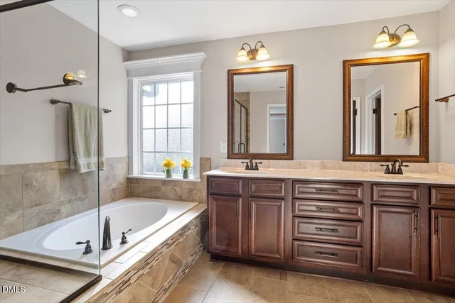 a bathroom with a tub a sink and a window
