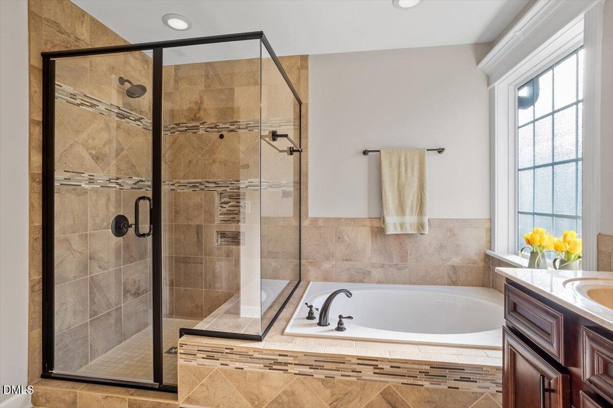 109 North Sunset Ridge Drive Willow Spring, NC 27592 - Photo 24 of 54 a bathroom with a tub a sink and a window