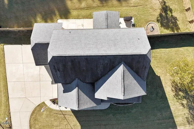 a view of a swimming pool with a yard and potted plants