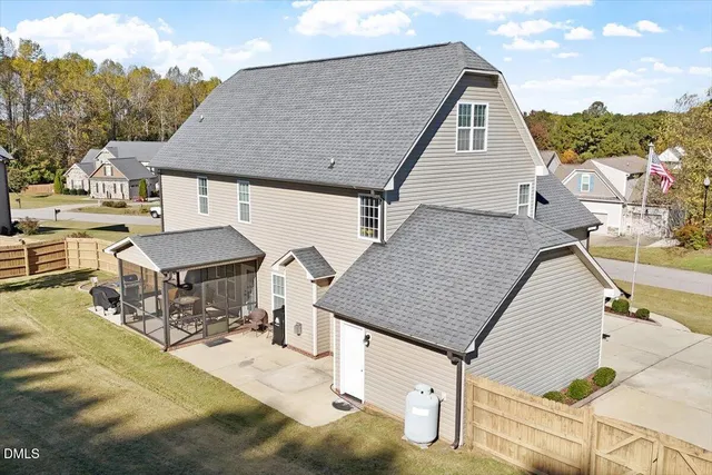 a view of a white house with a big yard and large trees