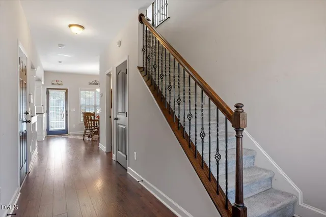 a view of a hallway with wooden floor and staircase