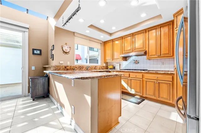 a large kitchen with kitchen island granite countertop a refrigerator and sink
