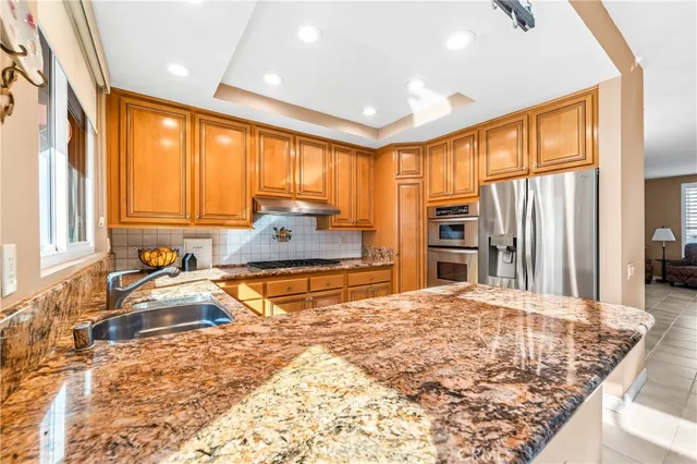 a kitchen with granite countertop stainless steel appliances and refrigerator
