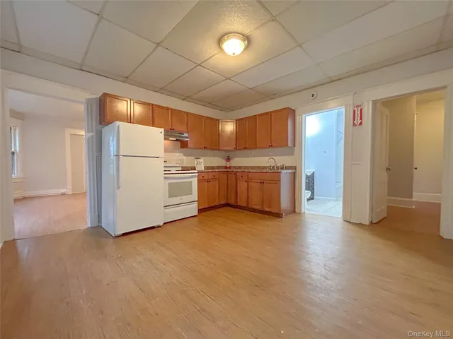 a view of a refrigerator in kitchen and a livingroom