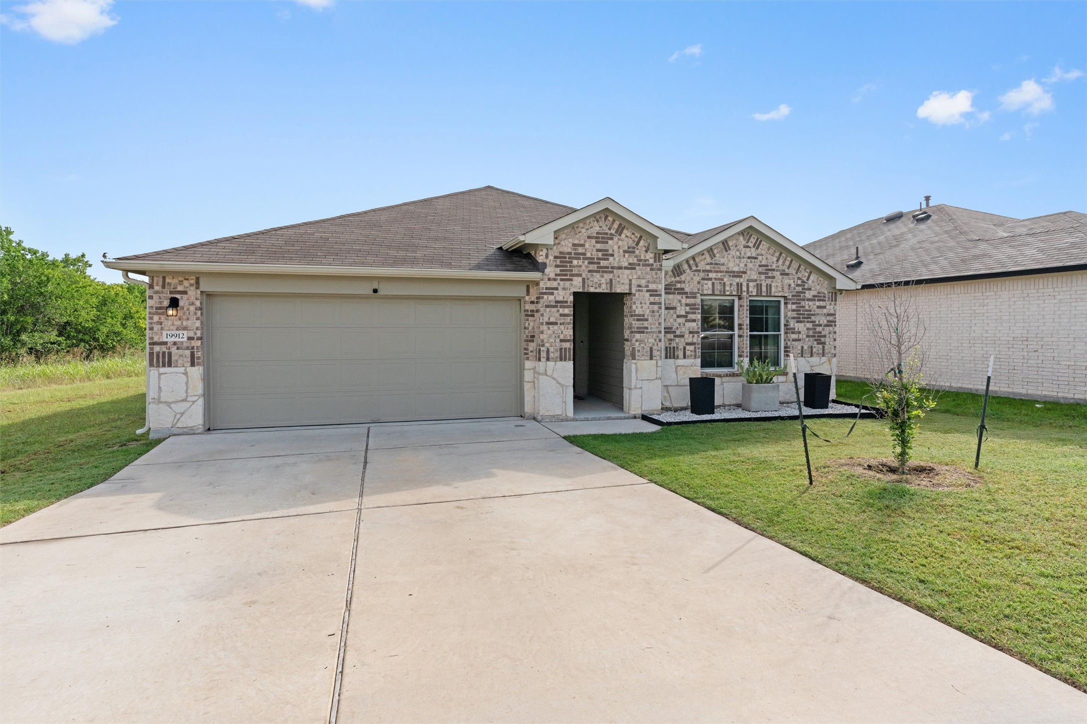 19912 Abigail Fillmore Road Manor, TX 78653 - Photo 29 of 31 A charming single-story residence with a brick and stone facade and an attached garage.