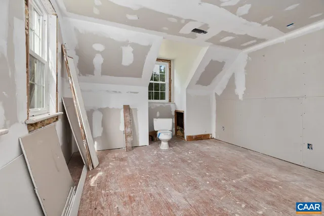 a view of a bedroom with wooden floor and bathroom