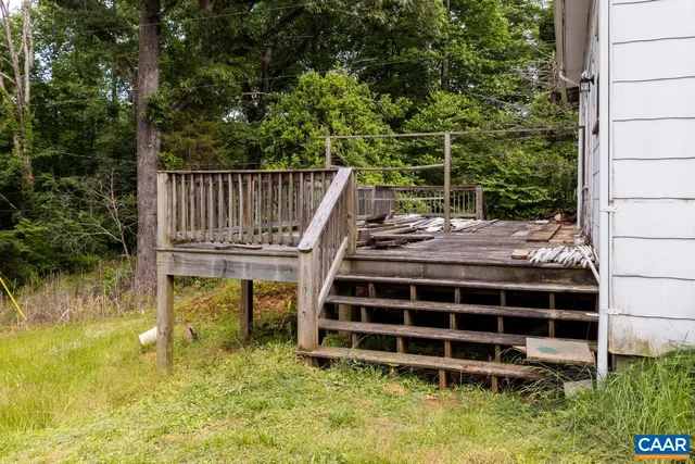 a view of an empty room with wooden floor and windows