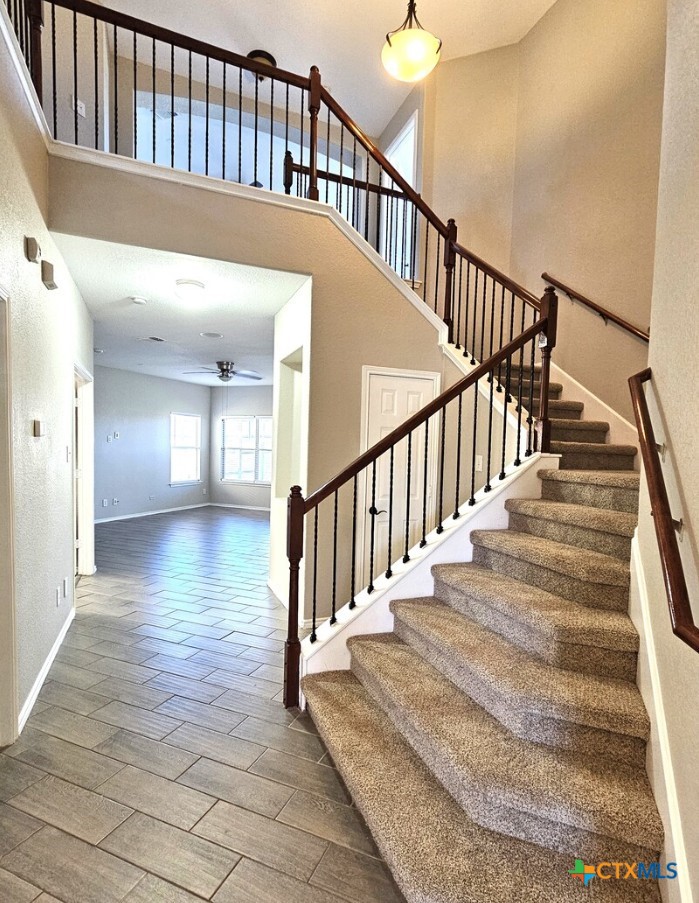316 Julian Point Cibolo, TX 78108 - Photo 2 of 28 a view of staircase with lots of frames on wall and wooden floor