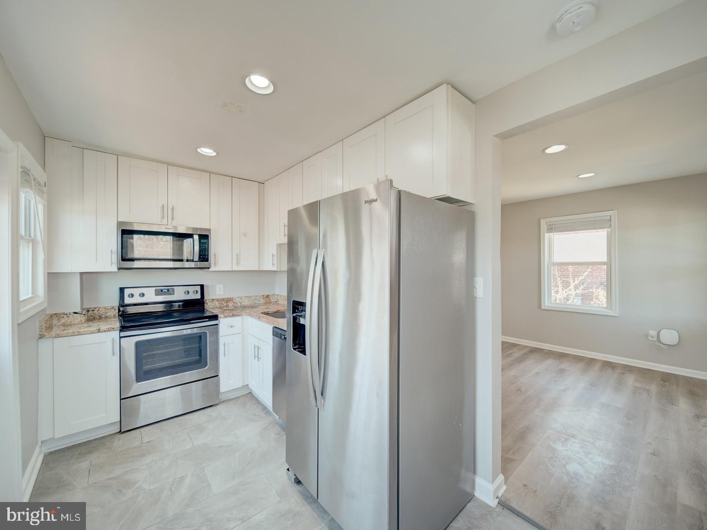 4217 Vine Street Capitol Heights, MD 20743 - Photo 18 of 60 a kitchen with stainless steel appliances granite countertop a refrigerator and a stove top oven