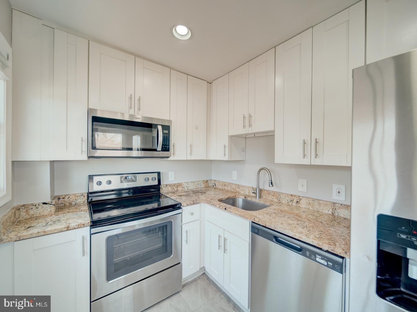 4217 Vine Street Capitol Heights, MD 20743 - Photo 20 of 60 a kitchen with granite countertop white cabinets and stainless steel appliances