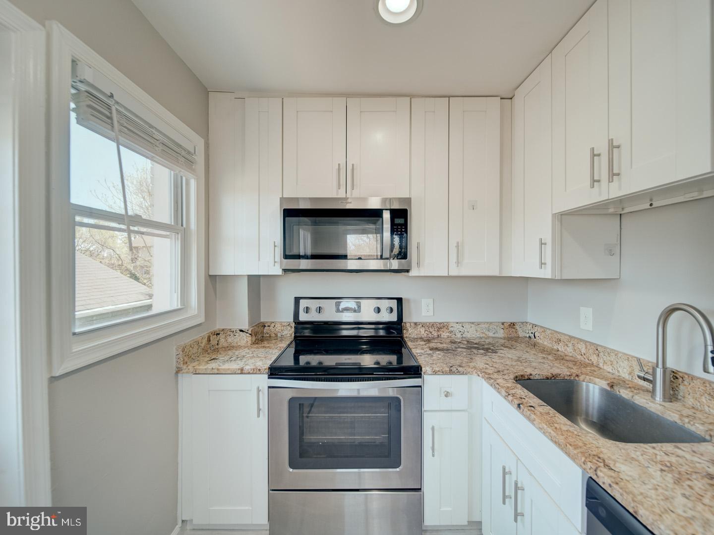 4217 Vine Street Capitol Heights, MD 20743 - Photo 22 of 60 a kitchen with granite countertop white cabinets and white stainless steel appliances