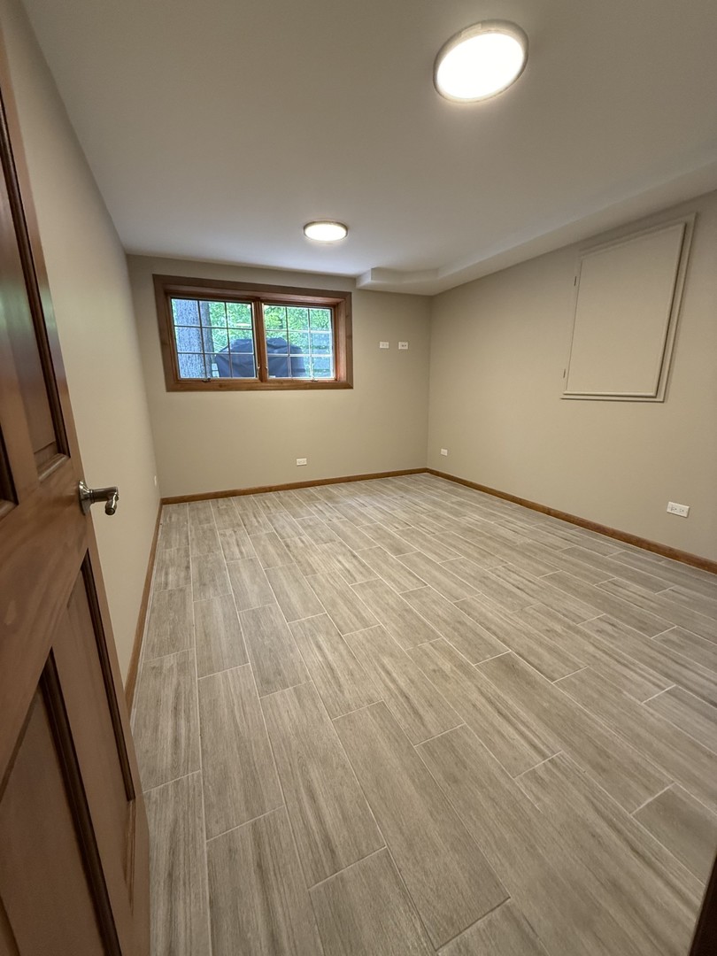 2841 Orange Brace Road Deerfield, IL 60015 - Photo 19 of 30 an empty room with wooden floor and windows