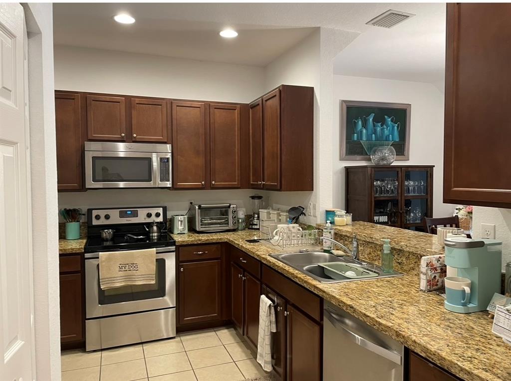 817 Southwest 147th Avenue, Unit 817 Pembroke Pines, FL 33027 - Photo 12 of 34 a kitchen with stainless steel appliances granite countertop a stove microwave and sink