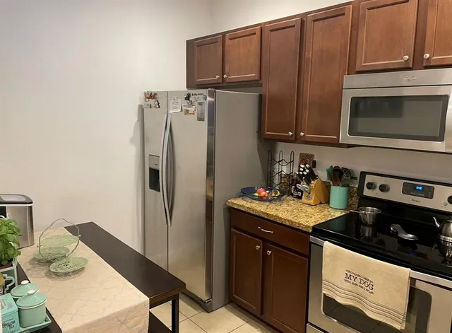 a kitchen with stainless steel appliances granite countertop a refrigerator stove and sink