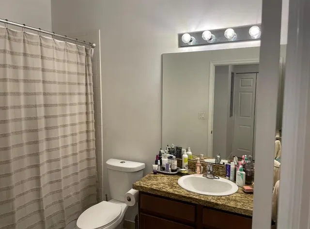 a bathroom with a toilet sink and mirror