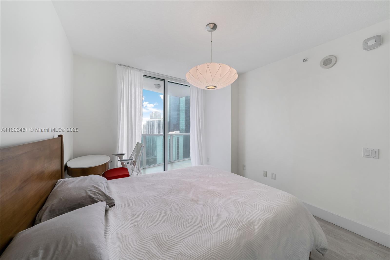 41 Southeast 5th Street, Unit 1709 Miami, FL 33131 - Photo 14 of 33 a bedroom with a bed and a chandelier