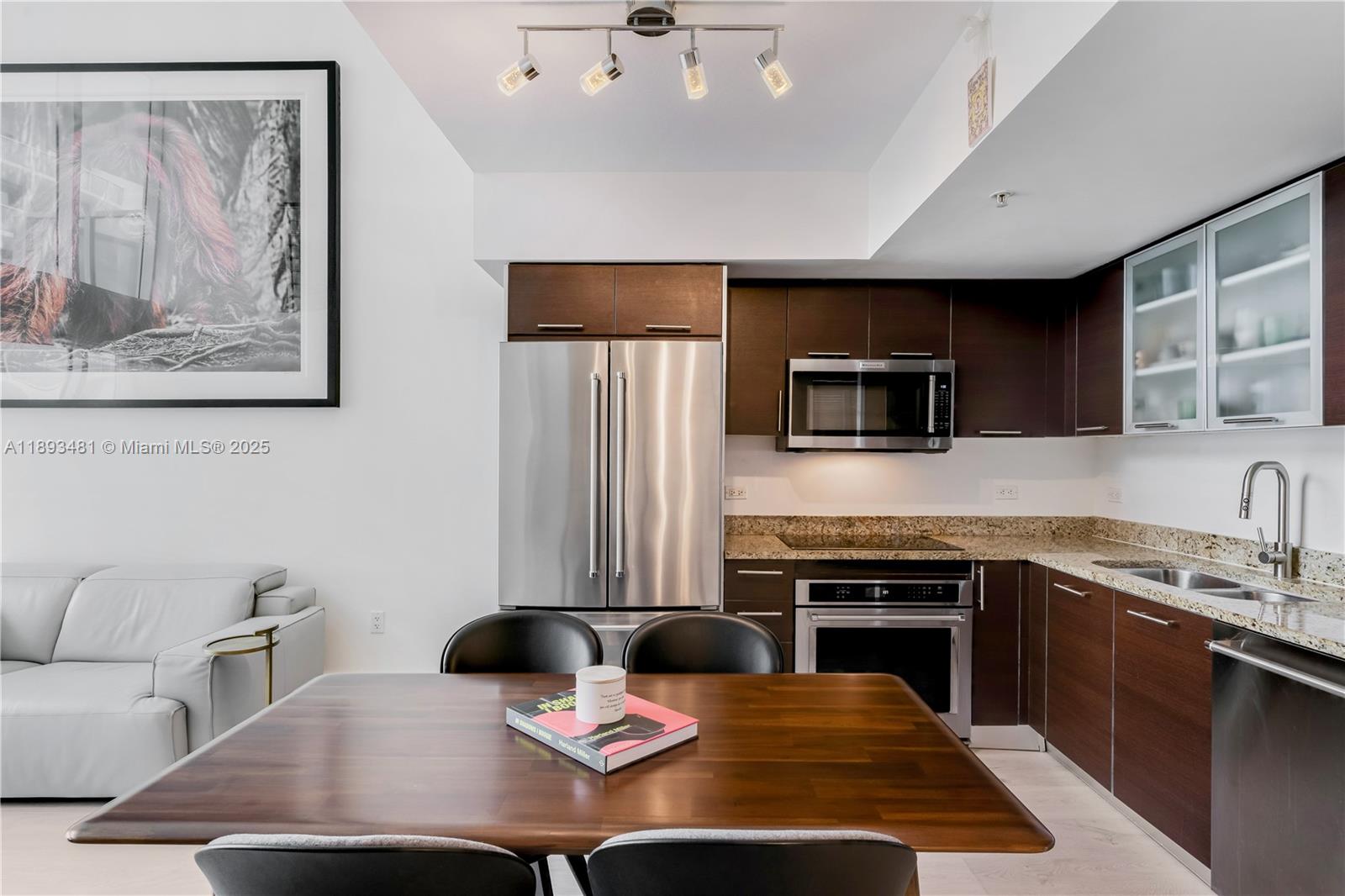 41 Southeast 5th Street, Unit 1709 Miami, FL 33131 - Photo 6 of 33 a kitchen with stainless steel appliances a stove a sink a microwave a refrigerator and cabinets
