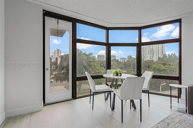 a dining room with furniture and large windows
