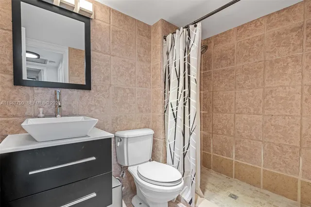 a bathroom with a toilet a sink and mirror