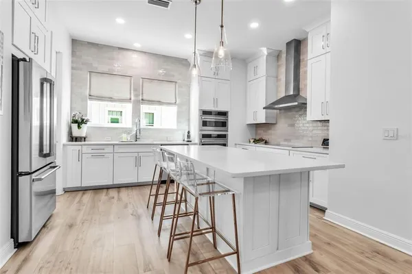 a kitchen with stainless steel appliances kitchen island a large island in the center and wooden floors