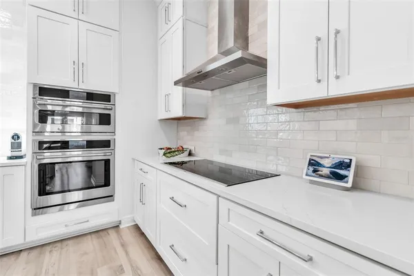 a kitchen with granite countertop white cabinets and white appliances
