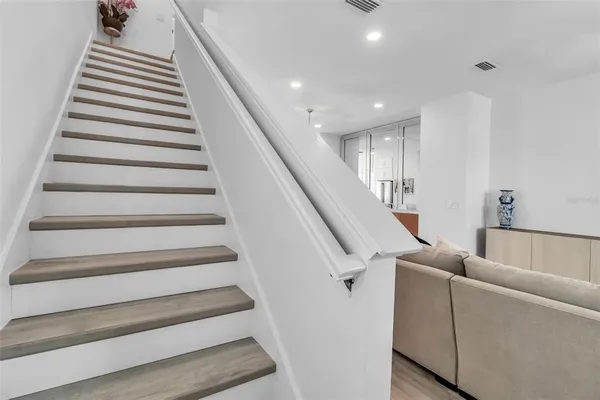 a living room with furniture and stairs