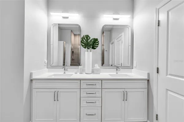 a bathroom with double sink and a mirror