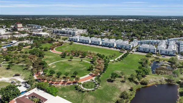 an aerial view of residential houses with outdoor space and trees