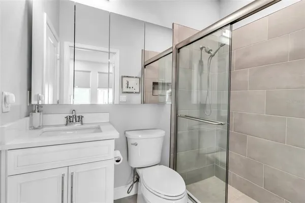 a bathroom with a sink a toilet and shower