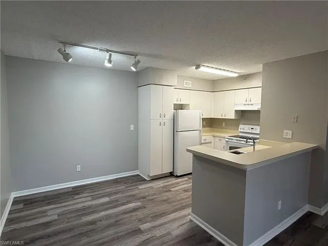 a kitchen with refrigerator cabinets and wooden floor
