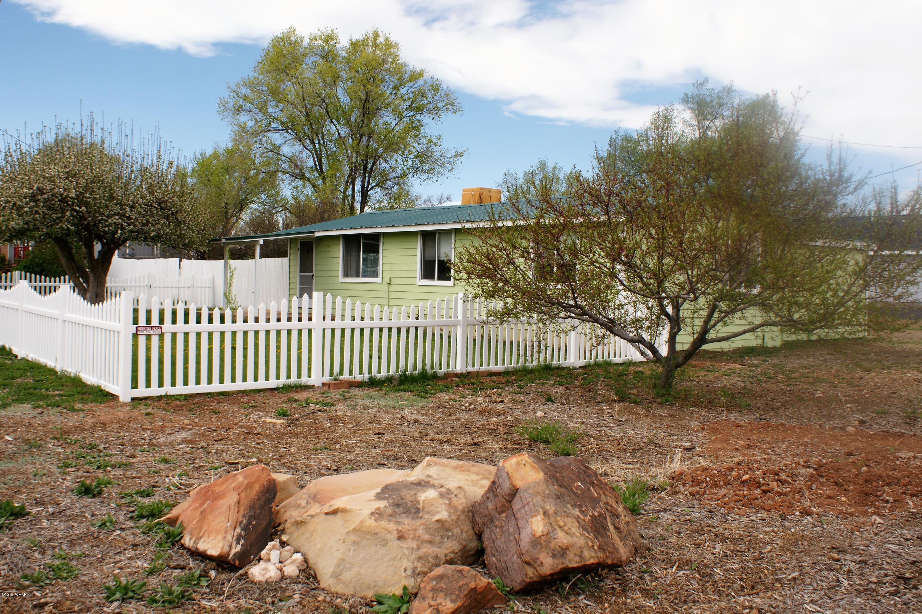 a view of a wooden house with a yard and fence
