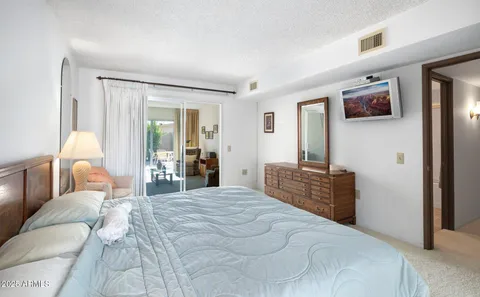 a bedroom with a large bed and flat screen tv
