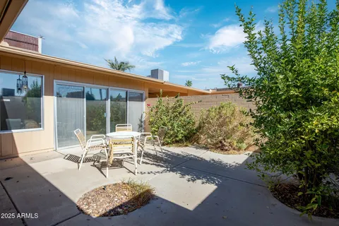 a view of a patio with couches table and chairs and potted plants