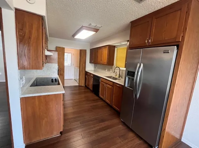 a kitchen with wooden cabinets sink and stainless steel appliances